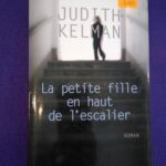 La petite fille en haut de l'escalier